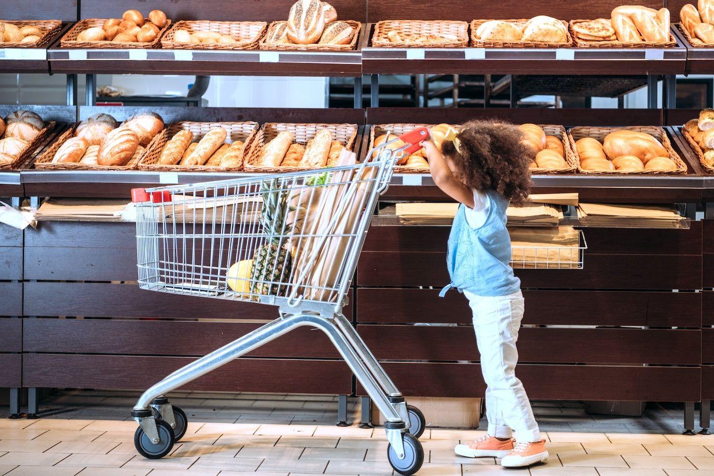 toddler pushing a shopping trolley