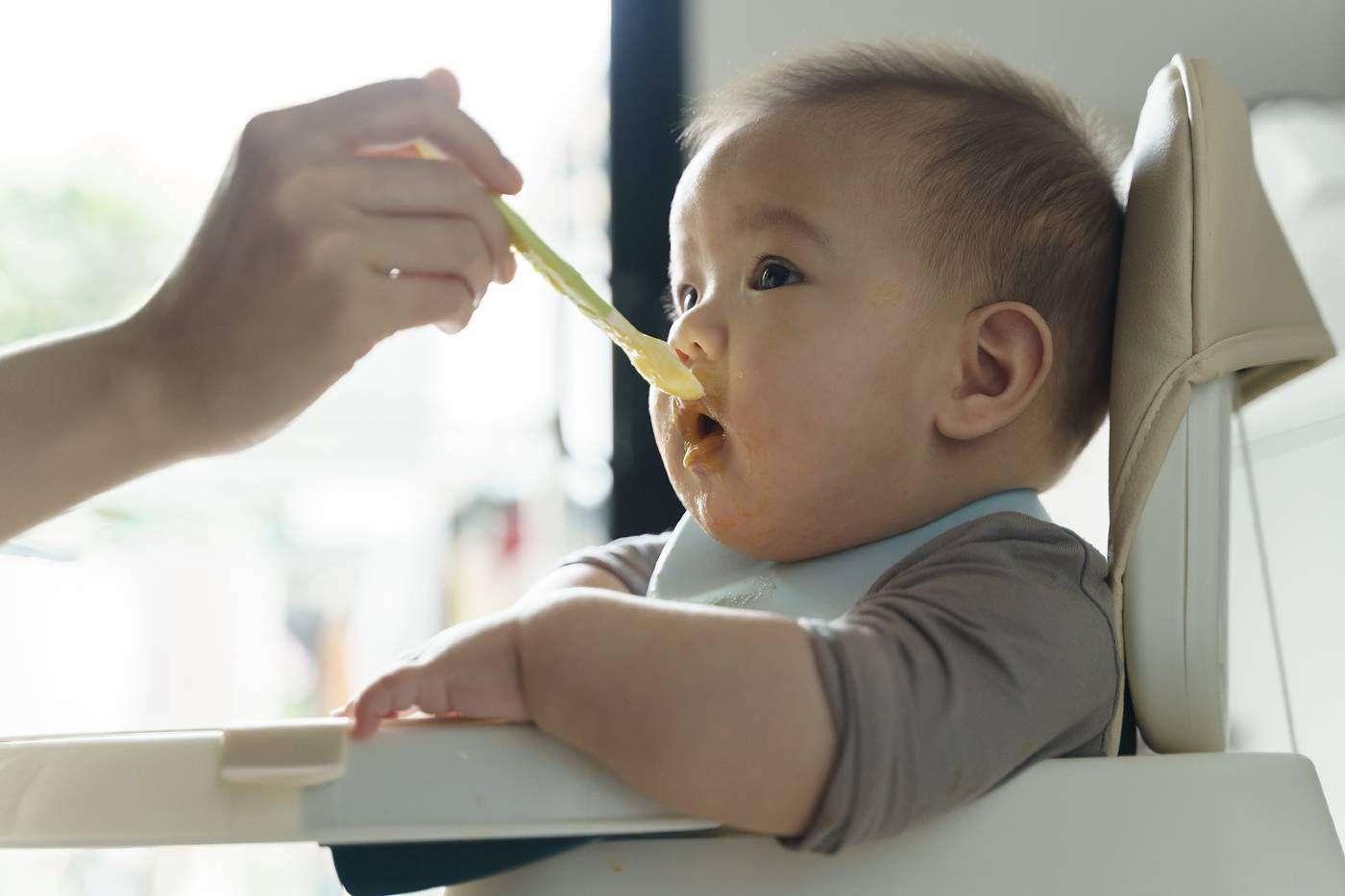 A parent spoon-feeds a baby a homemade puree