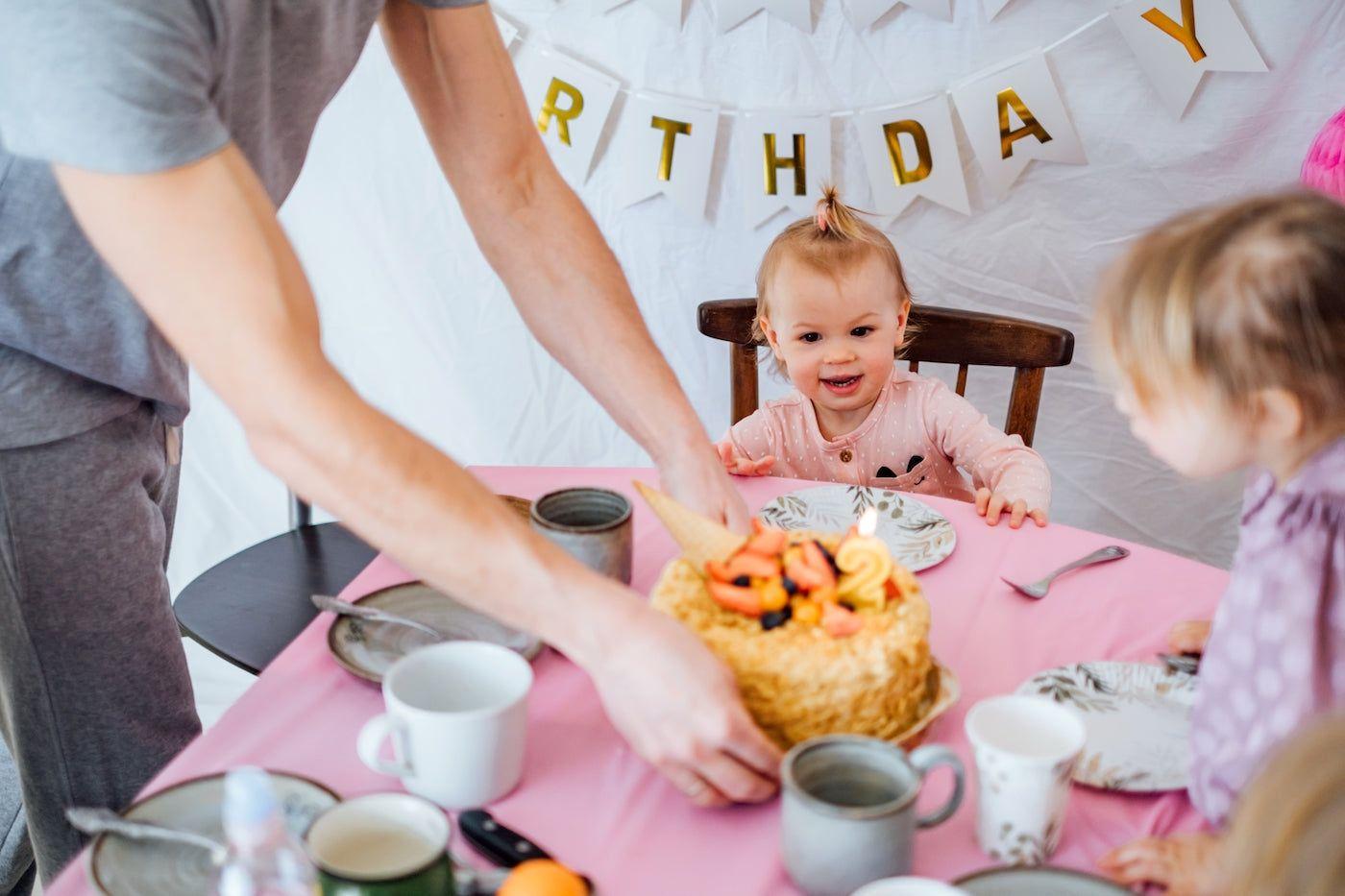 A baby girl celebrates her birthday with cake