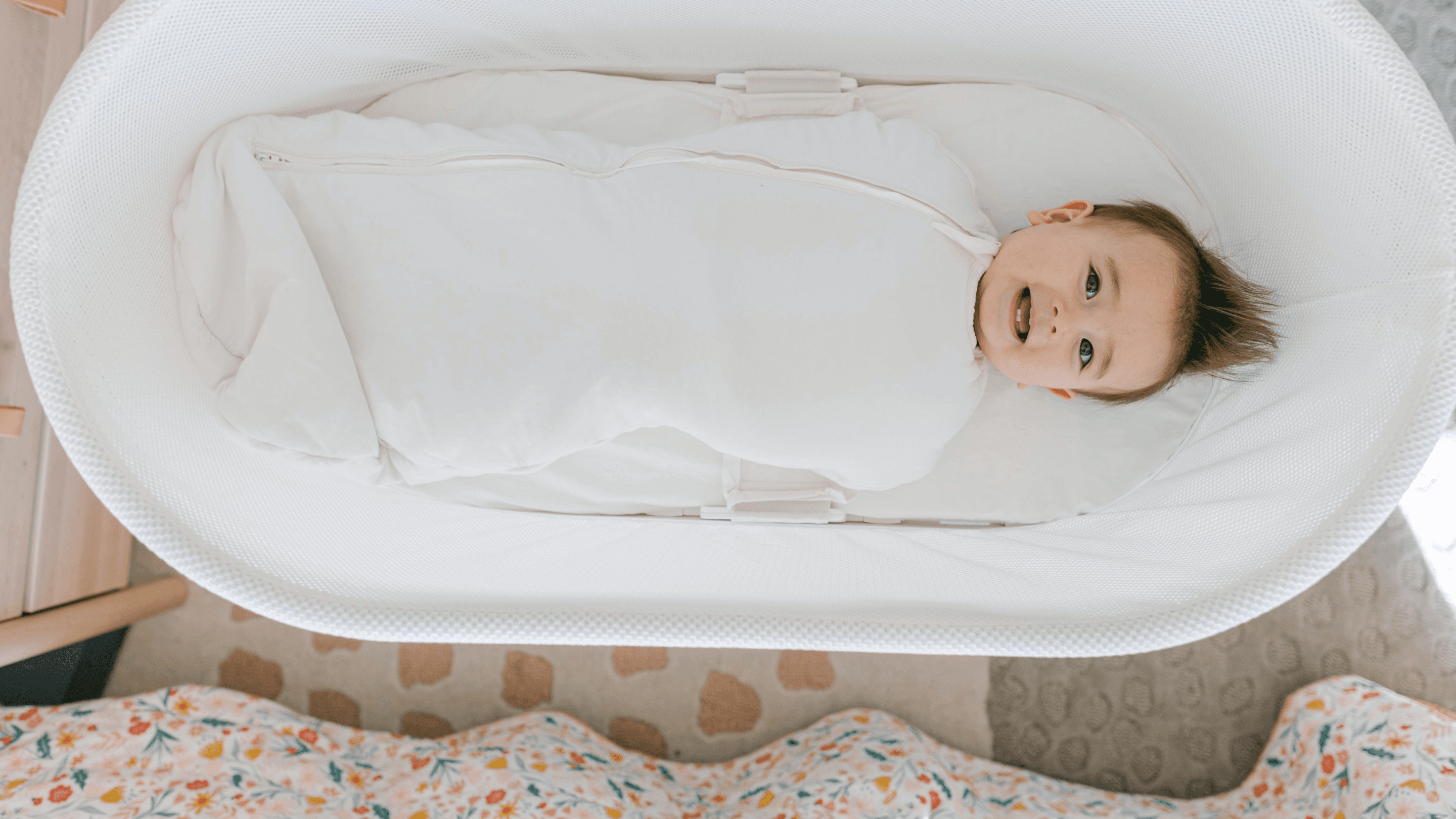Baby laying in SNOO tied in a Comforter Sack
