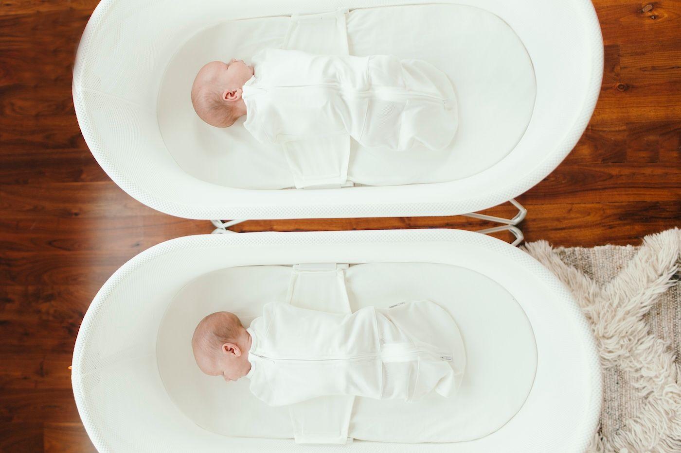 Twin babies sleeping in two SNOO Smart Sleepers