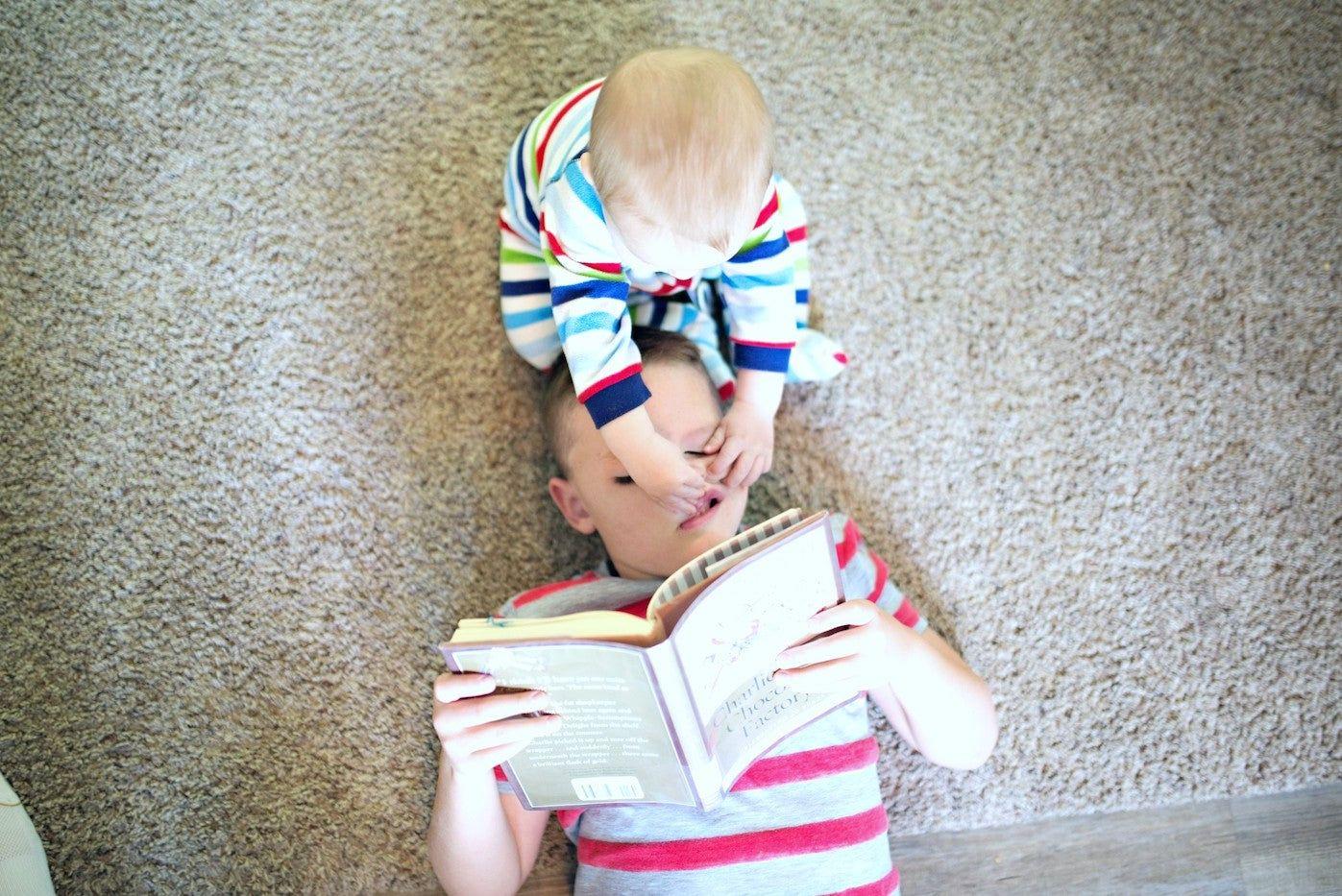 Baby pinching and bothering older brother